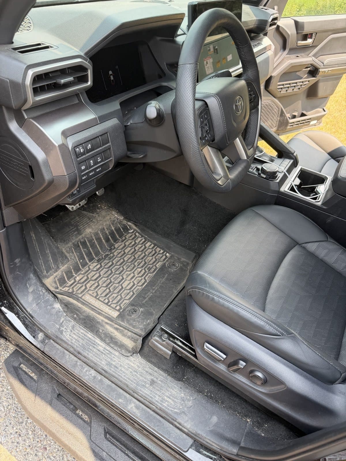 Toyota Tacoma driver side before detailing, with dust across the floor mat and door sill