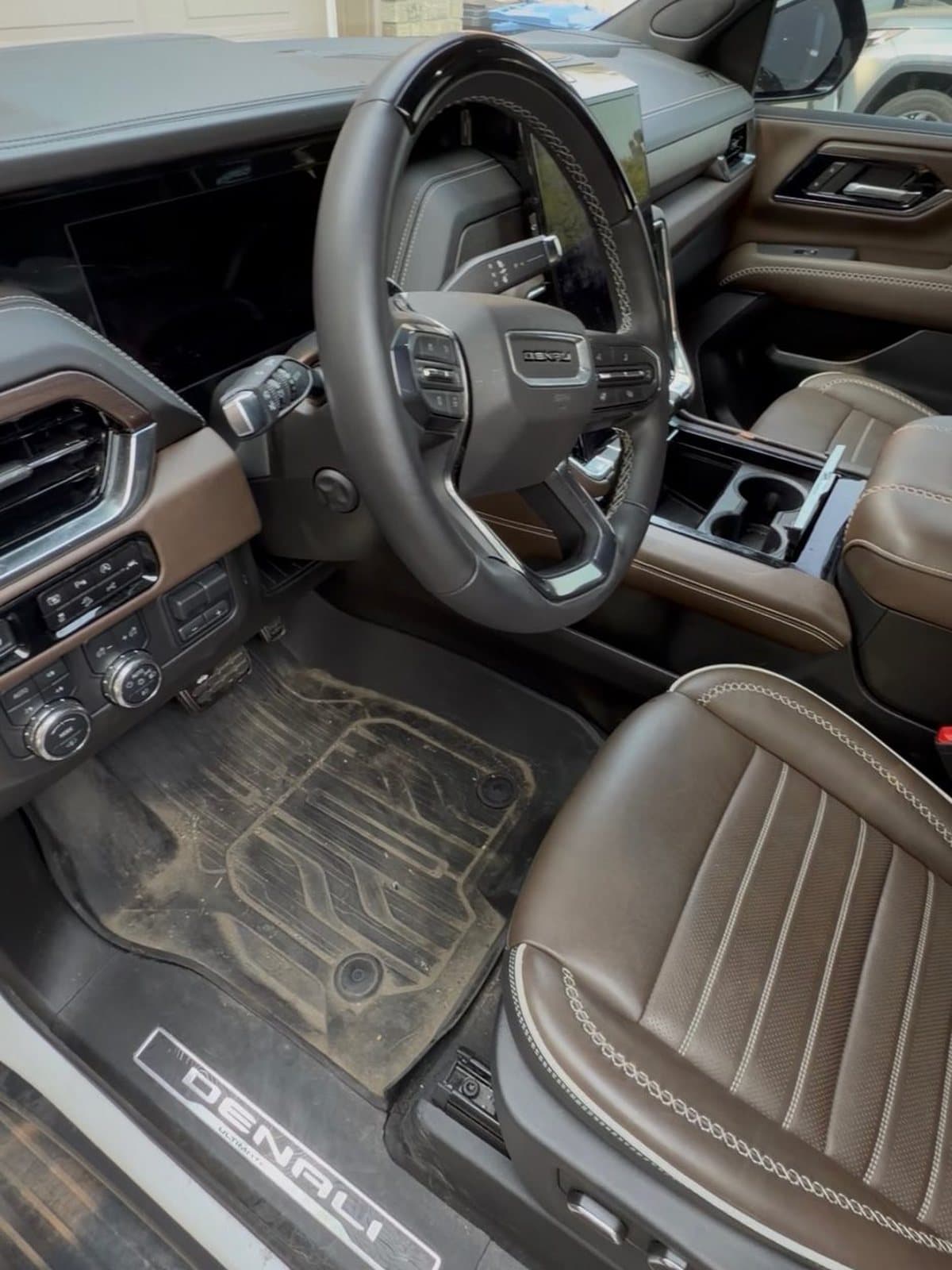 GMC Denali driver side before detailing, with a dust-covered floor mat