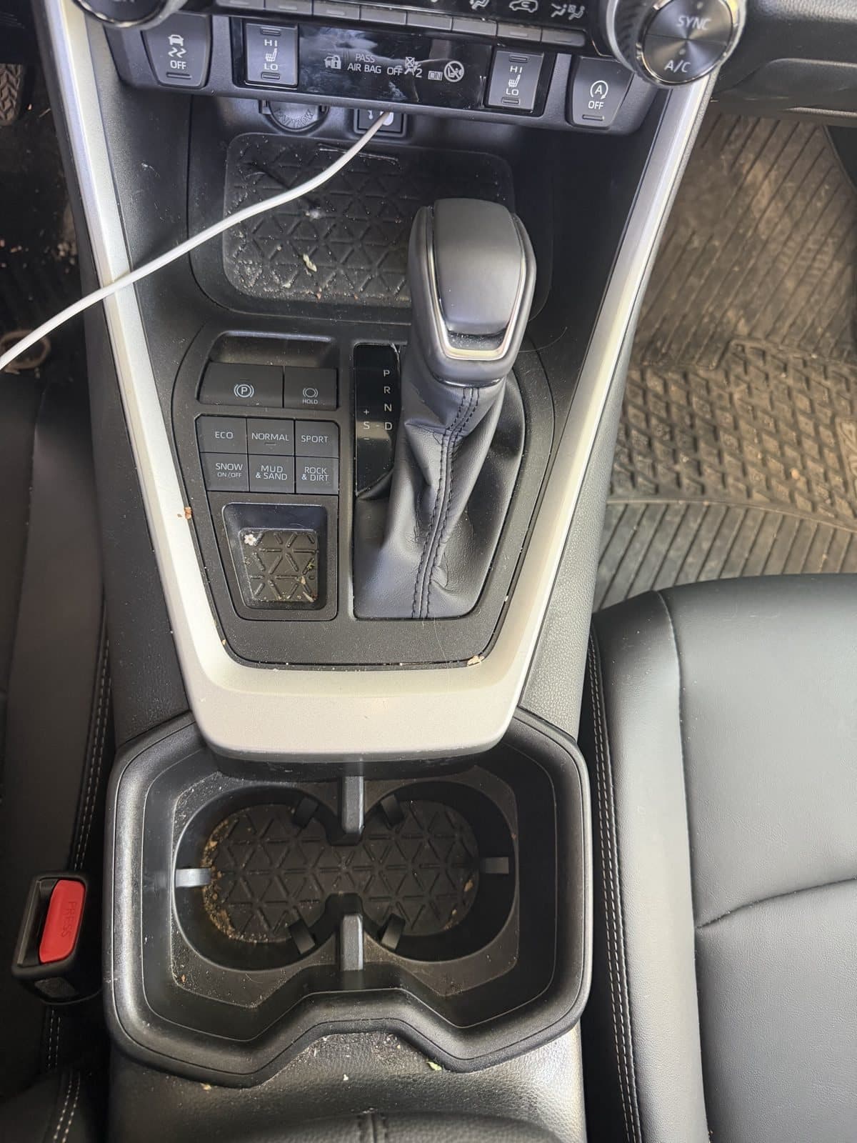RAV4 centre console before detailing, with crumbs and debris through the shifter surround and cup holders